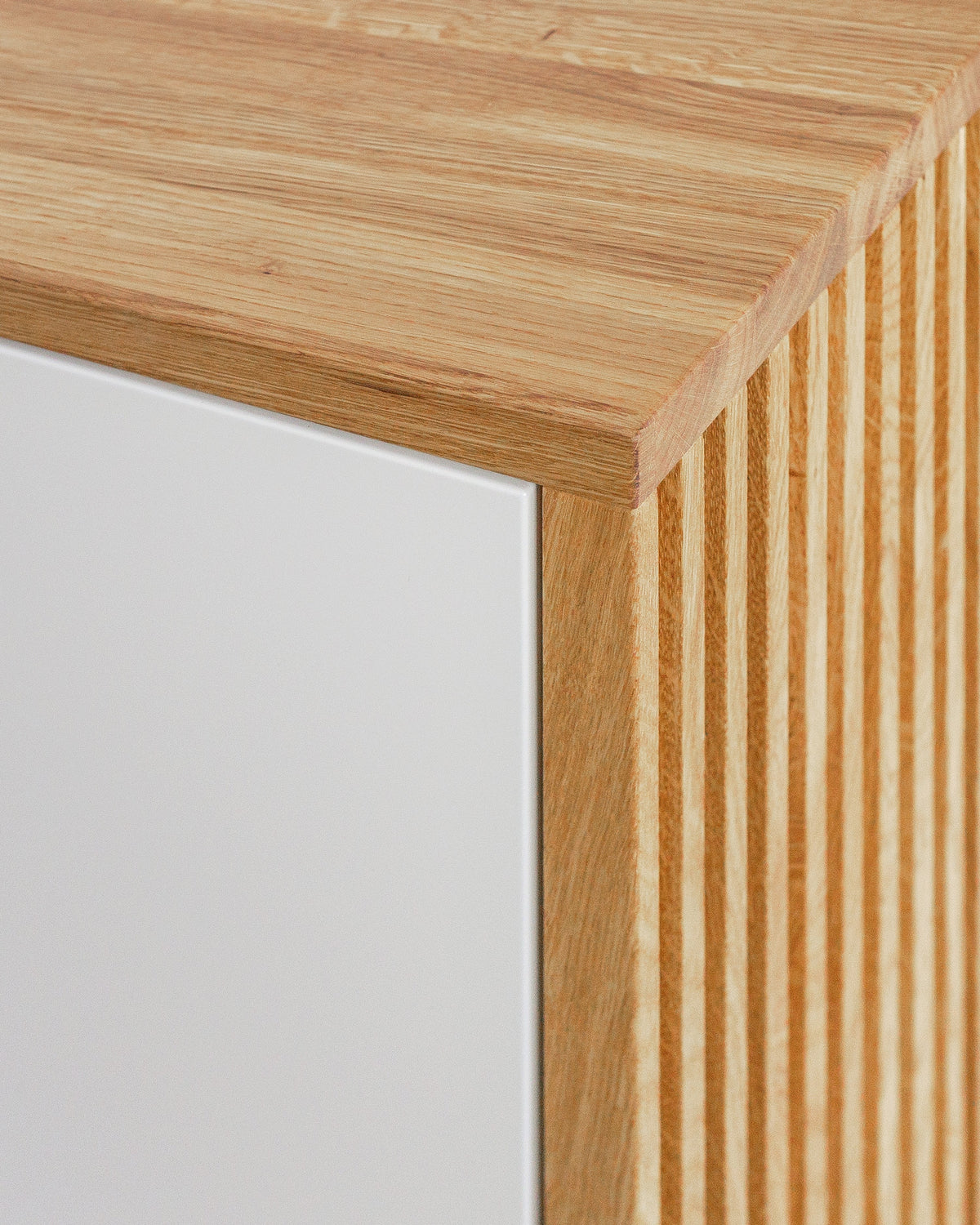 Sideboard S in Eiche weiß offen:Lamellen mehr als Optik:Die Lamellenoptik entsteht durch das Einsägen von Nuten in massive Eichebretter, wodurch Ihr Möbelstück stabil bleibt.